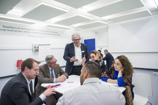 Groupe avec Professeur Gruppenbesprechung an einem Tisch mit dem Lehrer