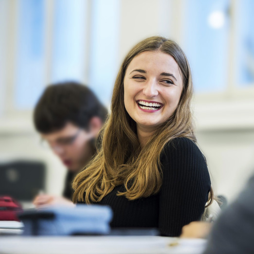 Woman HEGFR Studentin, lachend, während einer Vorlesung