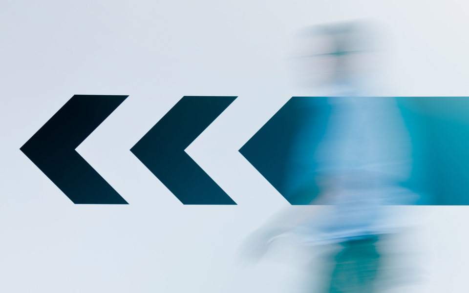 Arrow on a wall with a blurry person in the foreground 